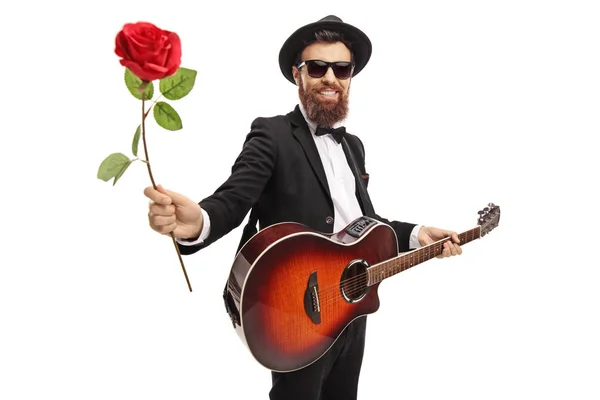 Joven Barbudo Con Una Guitarra Acústica Sosteniendo Una Rosa Roja — Foto de Stock