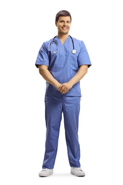 Mavi üniformalı genç erkek doktor poz veriyor ve gülümsüyor. — Stok fotoğraf