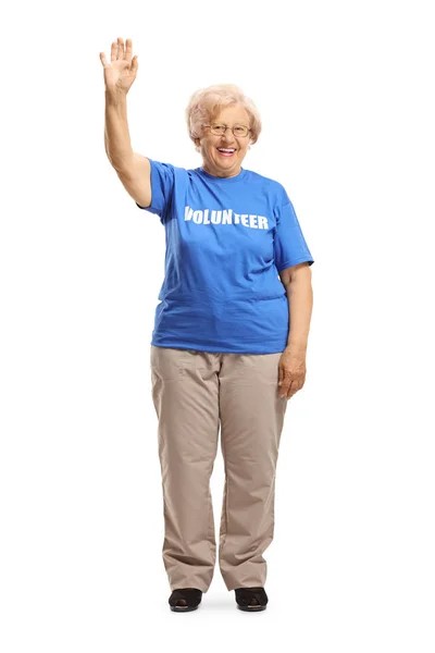 Oudere dame vrijwilliger zwaaien op de camera — Stockfoto