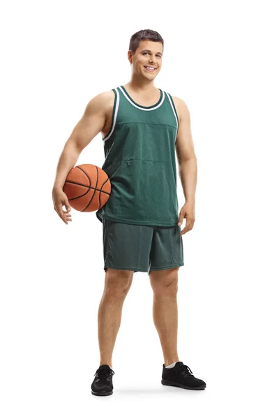 ボールを持ち 白い背景に隔離されたカメラに微笑むジャージを着たハンサムなバスケットボール選手の全長の肖像画 — ストック写真