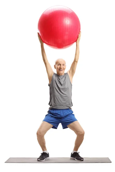 Homem idoso se exercitando com uma bola de fitness — Fotografia de Stock
