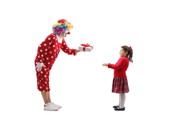 Clown handing a present to a little girl — Stock Photo, Image