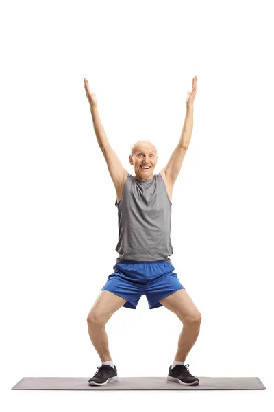 Uomo anziano esercizio su un tappeto — Foto Stock