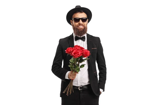 Елегантний молодий чоловік тримає купу червоних троянд — стокове фото