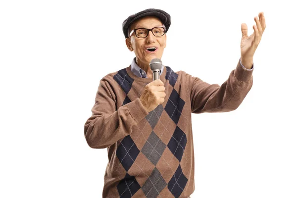 Happy elderly man singing on a microphone and gesturing with han — Stock Photo, Image