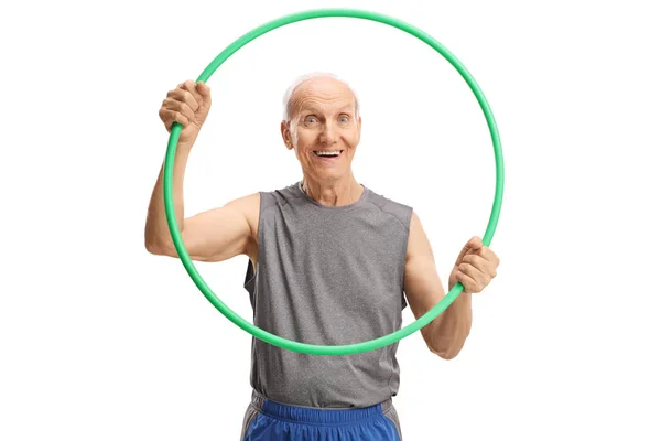 Lachende oudere man met een hula hoop en kijkend naar de camer — Stockfoto
