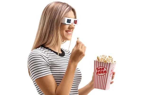 Молодая женщина ест попкорн и смотрит в 3D очки — стоковое фото