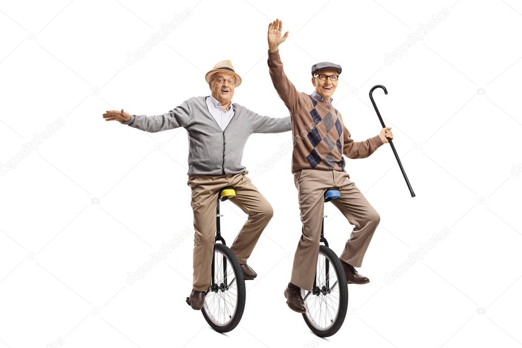 Two cheerful senior men riding unicycles 