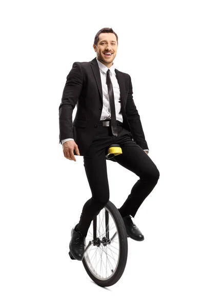 Businessman riding a unicycle and smiling at the camera — Stock Photo, Image