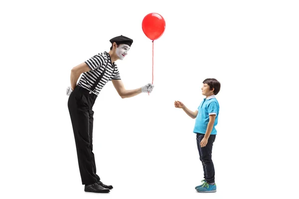 Mime donnant un ballon rouge à un petit garçon — Photo
