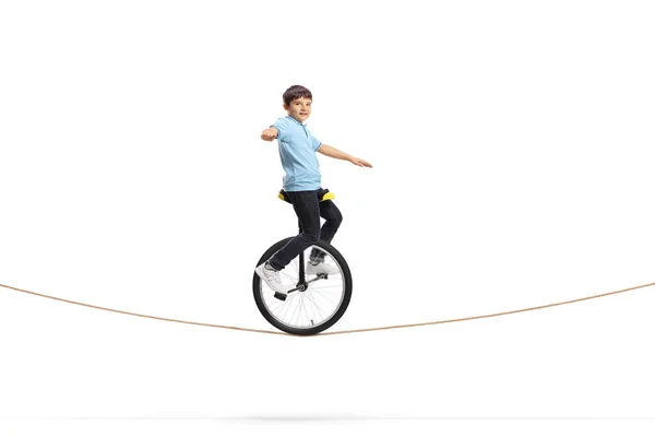 Boy riding a unicycle on a rope — Stock Photo, Image