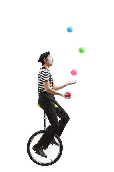 Mime on a unicycle juggling with balls — Stock Photo, Image
