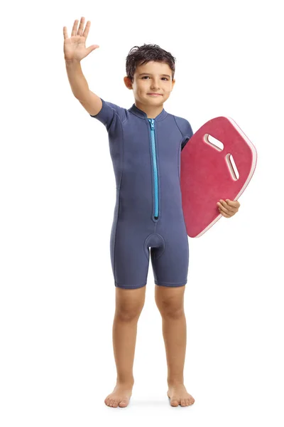 Kind in een wetsuit met een zwemfloatbord en zwaaiende — Stockfoto