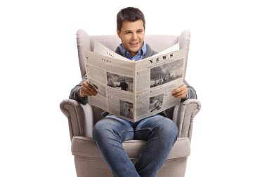 Adam bir koltukta oturur ve gazete okur.