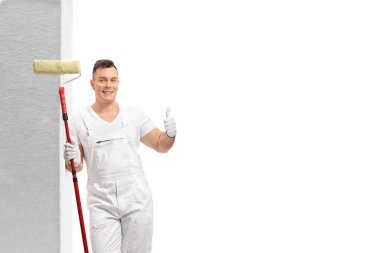 Duvara yaslanmış ve beyaz arka plan üzerinde izole bir başparmak kadar işaret yapma bir boya rulo ile Ressam