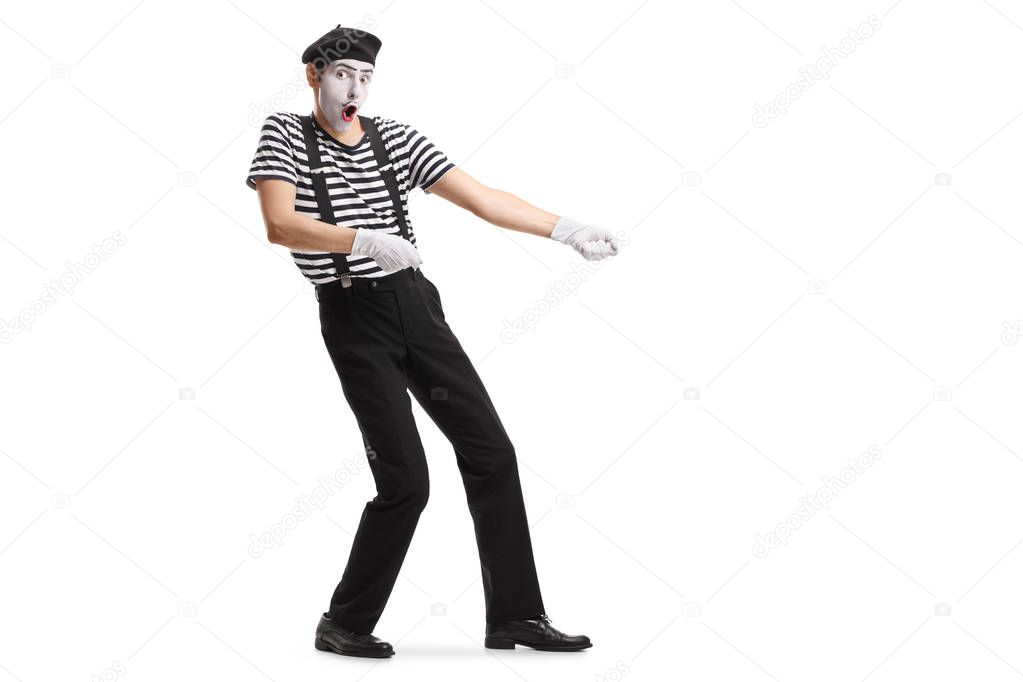 Full length shot of a mime pretending to pull a rope isolated on white background