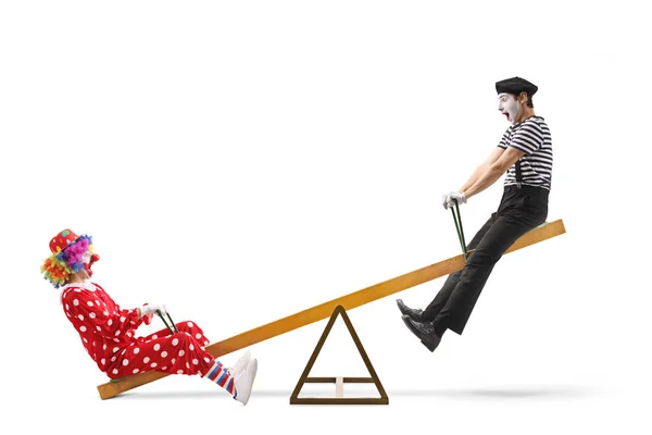 Clown and a mime playing on a seesaw — Stock Photo, Image