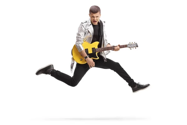 Young male guitarist jumping and playing — Stock Photo, Image