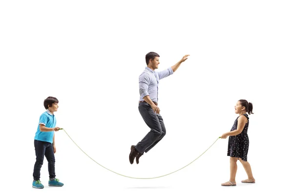 Pai pulando uma corda segurada por seu filho e filha — Fotografia de Stock