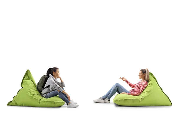 Vrouwelijke studenten zitten op zitzakken en praten — Stockfoto