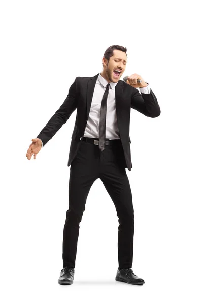 Young man in a suit singing on a mic — Stock Photo, Image