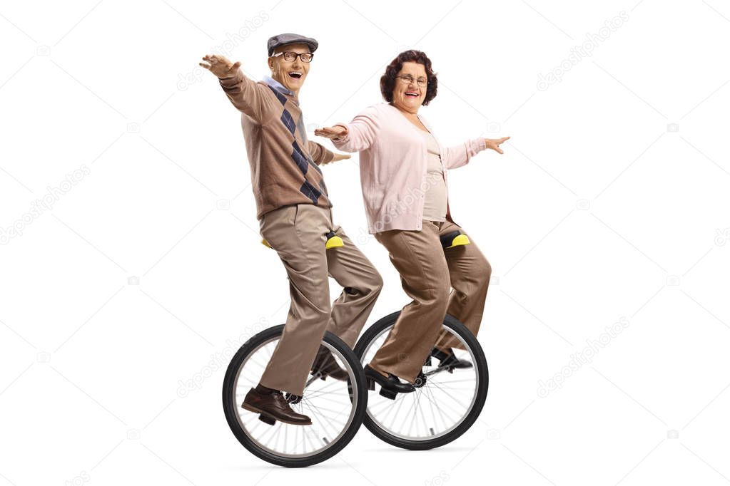 Senior man and woman riding unicycles and smiling