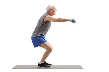Kıdemli adam squats egzersiz ve dumbbells tutarak