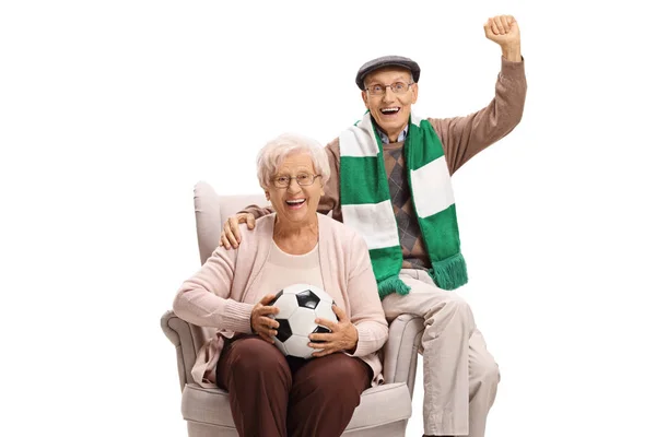 Alegre hombre y mujer mayores fanáticos del fútbol con un fútbol y un — Foto de Stock