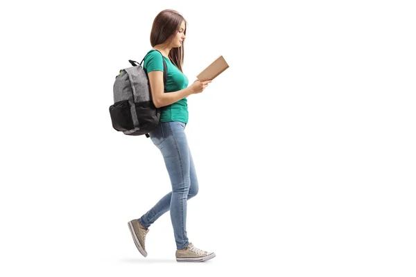 Fmale with a backpack reading a book and walking — Stock Photo, Image