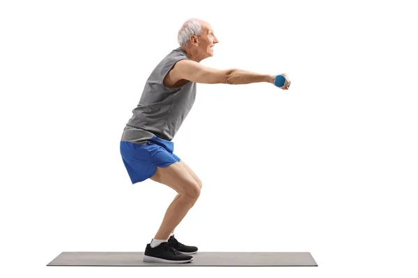 Senior man exercising squats and holding dumbbells — Stock Photo, Image