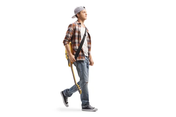 Guy carrying a guitar on a shoulder belt and walking — Stock Photo, Image