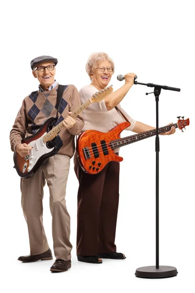 Senior couple with electric guitars singing on a microphone — Stock Photo, Image