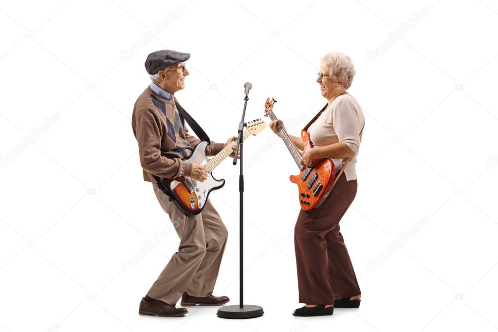 Senior man and woman playing electric guitars