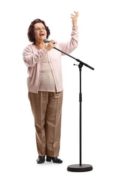 Starsza kobieta śpiewająca na mikrofonie — Zdjęcie stockowe