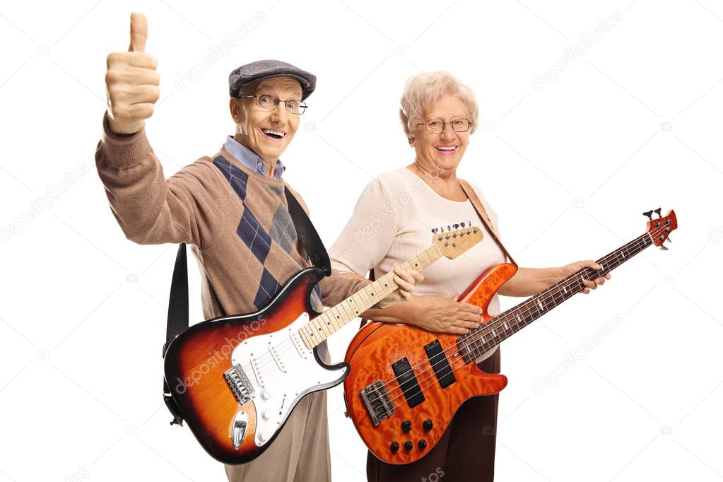 Elderly man and woman with electric guitars showing thumbs up