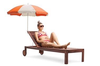 Şemsiyeile şezlong üzerinde bikini genç güzel kadın