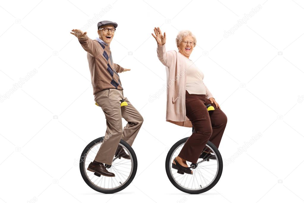 Elderly man and woman riding unicycles and smiling at the camera