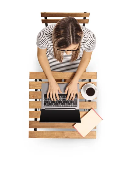 Top view of a young woman working on a laptop on a wooden table — Stock Photo, Image