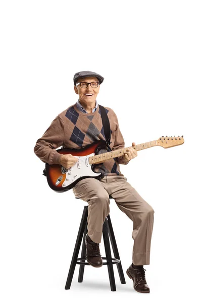 Homme âgé assis sur une chaise avec une guitare électrique — Photo