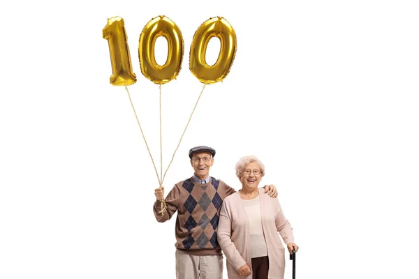 Senior man and woman with a golden number hundred balloon — Stock Photo, Image