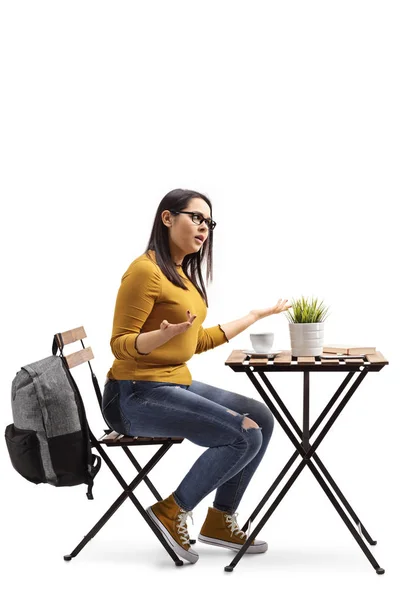 Estudante zangada em um café sentado a uma mesa e gesticulando — Fotografia de Stock