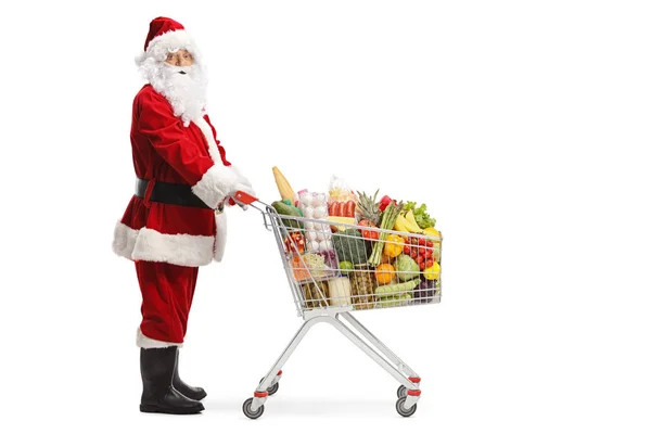 Yemek ürünleri dolu bir alışveriş sepeti ile Santa Claus — Stok fotoğraf