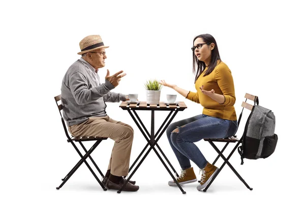 Angry female student in a cafe sitting at a table and arguing wi — Stock Photo, Image