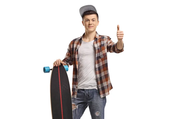 Adolescente masculino com um longboard fazendo um sinal de polegar para cima — Fotografia de Stock
