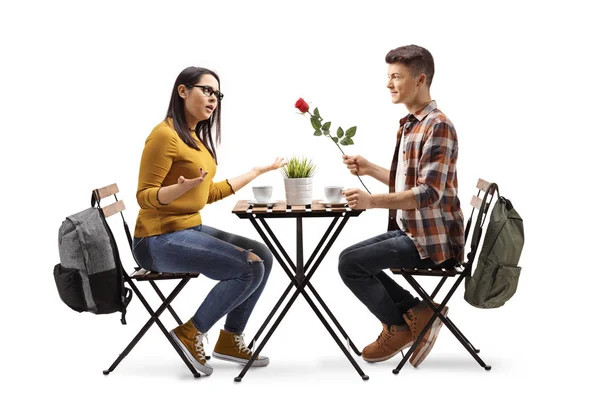 Jonge man geeft een geschenk aan een gelukkige jonge vrouw in een restauran — Stockfoto
