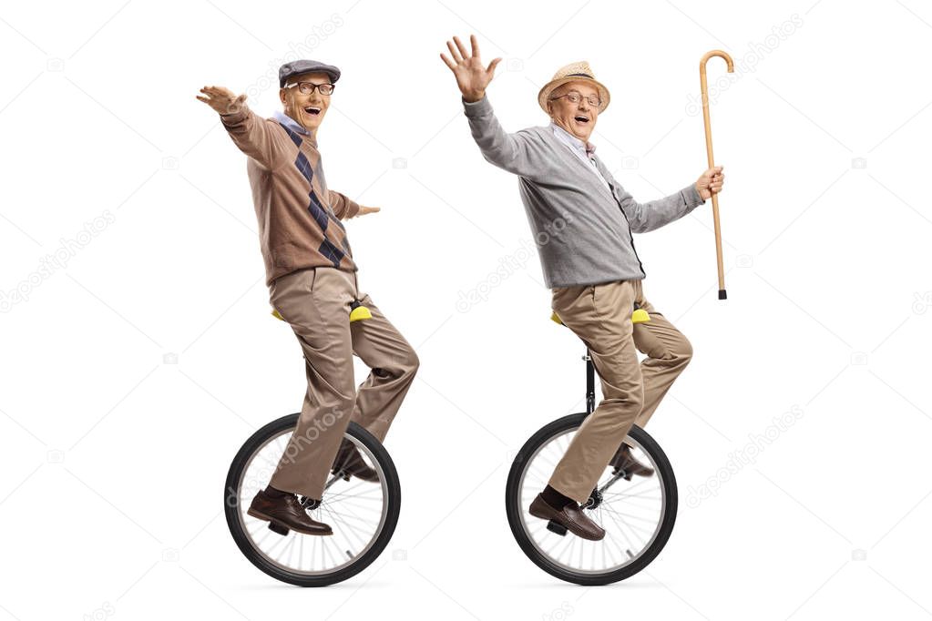 Two cheerful senior men riding unicycles and looking at the came