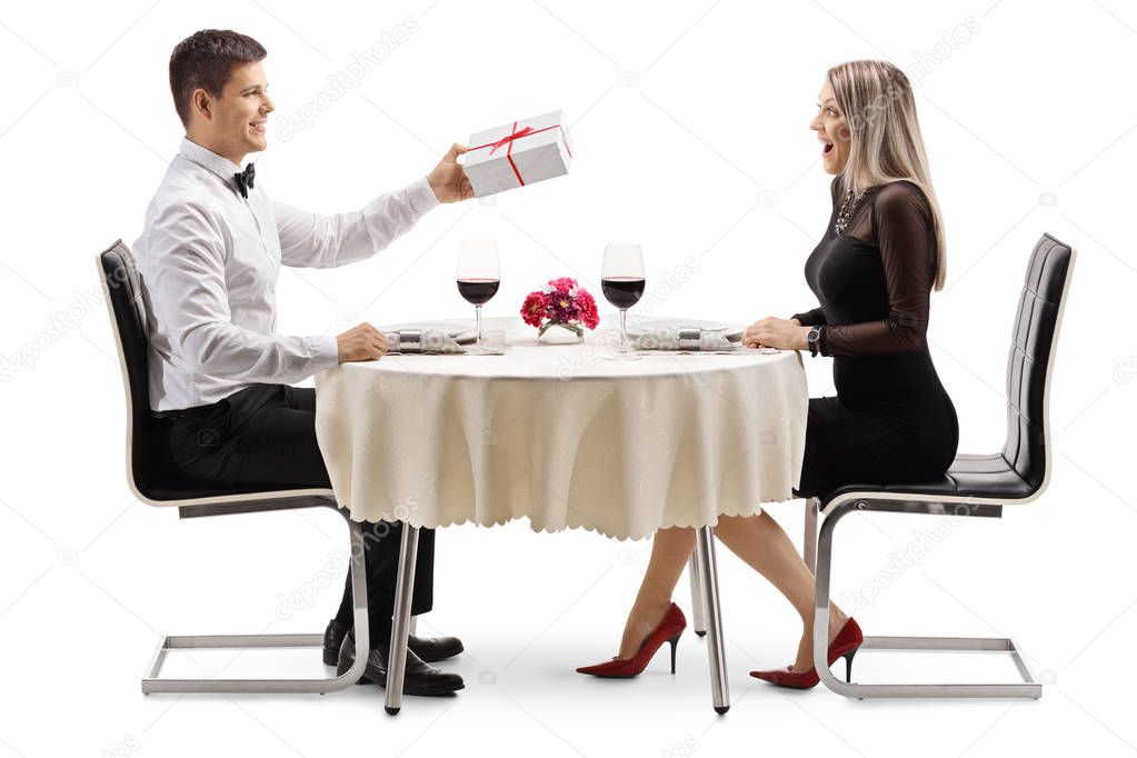 Male student in a cafe giving a red rose to a an angry female