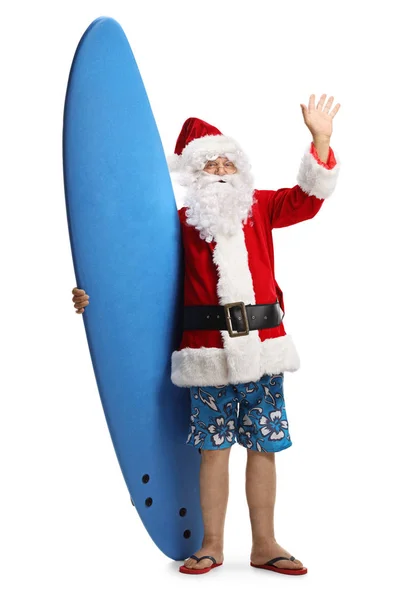 Happy santa claus on a holiday with a surfboard waving at the ca — Stock Photo, Image