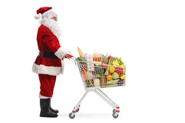 Babbo Natale in piedi con un carrello della spesa con cibo — Foto Stock