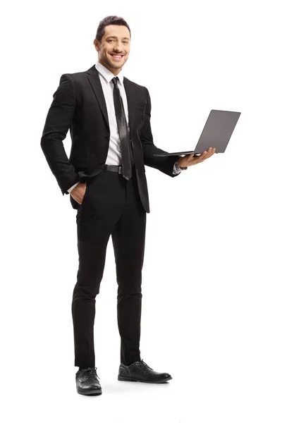 Молодий чоловік у костюмі тримає ноутбук і посміхається — стокове фото